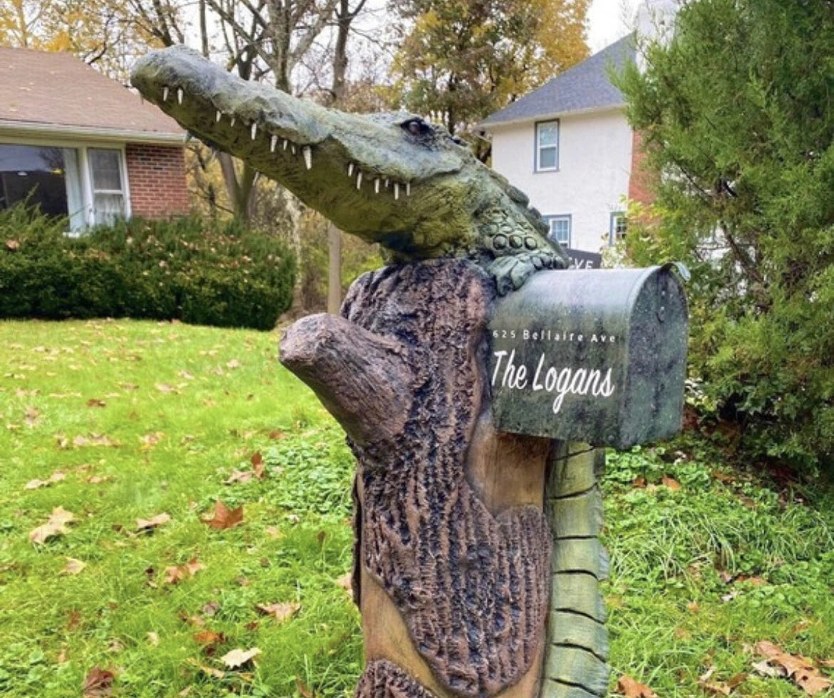 Alligator mailbox with florida address on a grassy lawn.