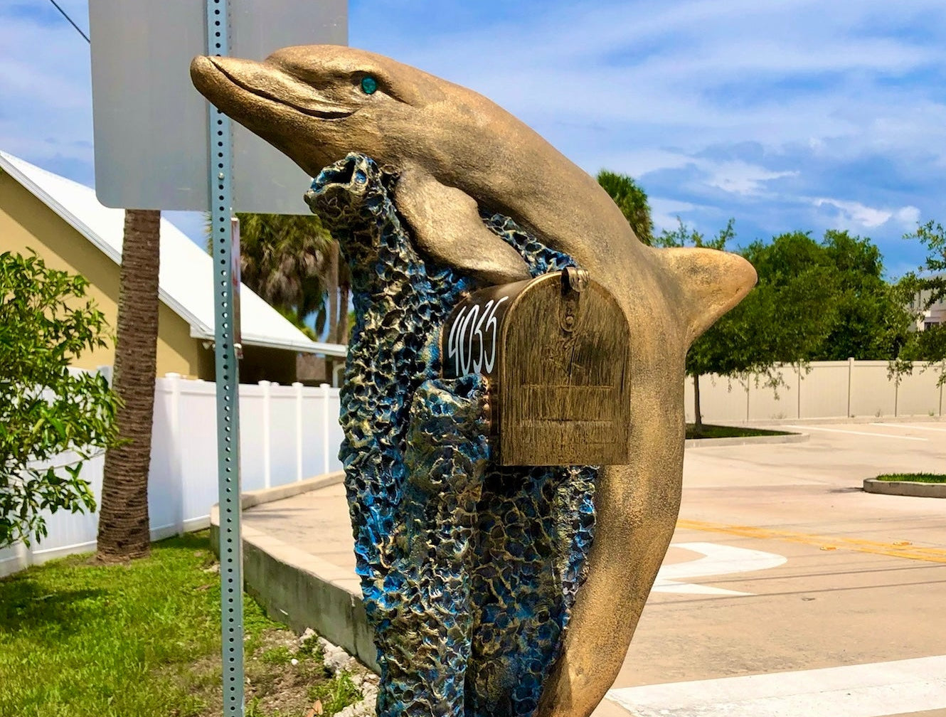 Mailbox shaped like a shark with camouflage pattern on a street corner