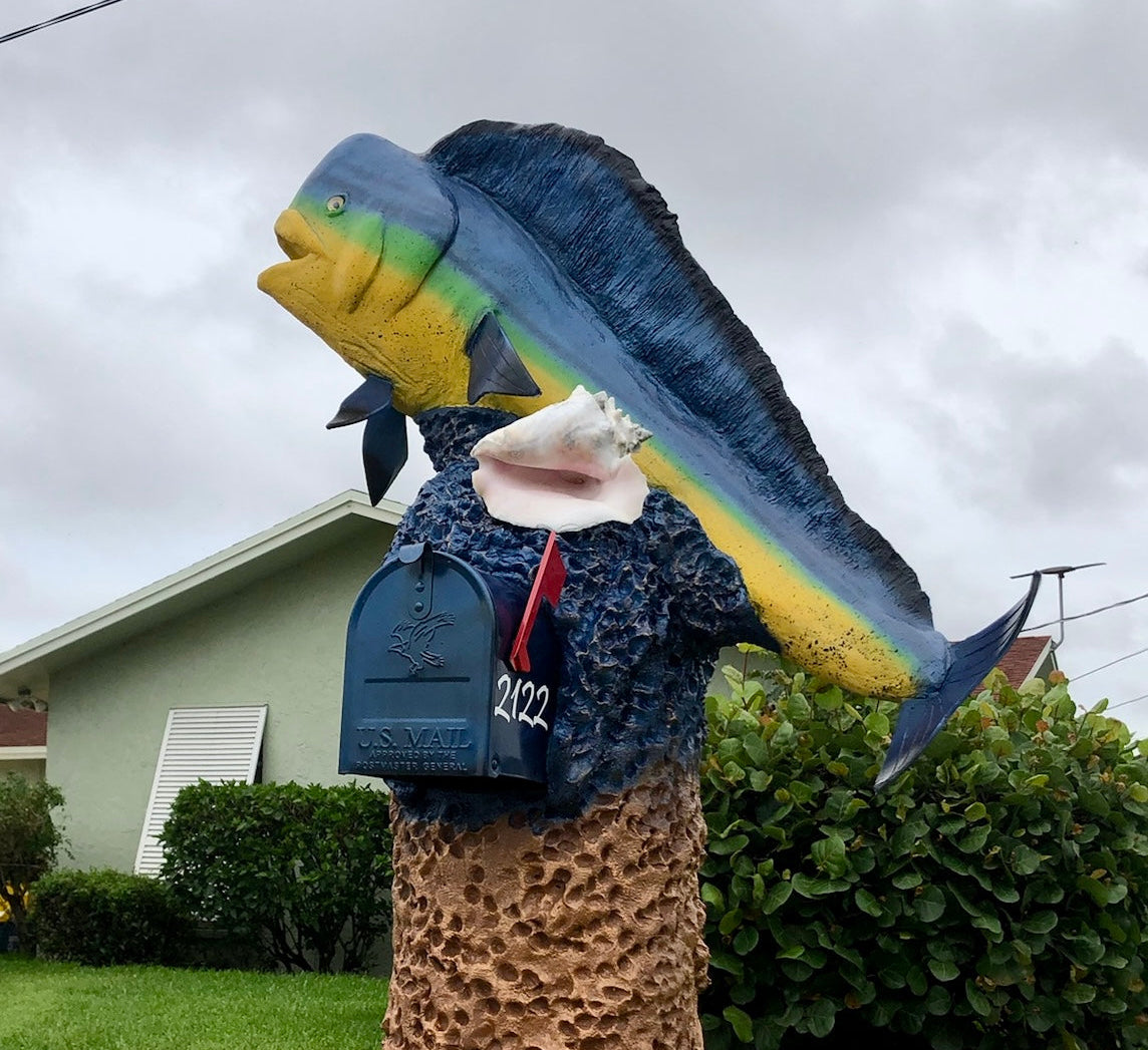 Fishing lure on a stand in a grassy area with a house in the background