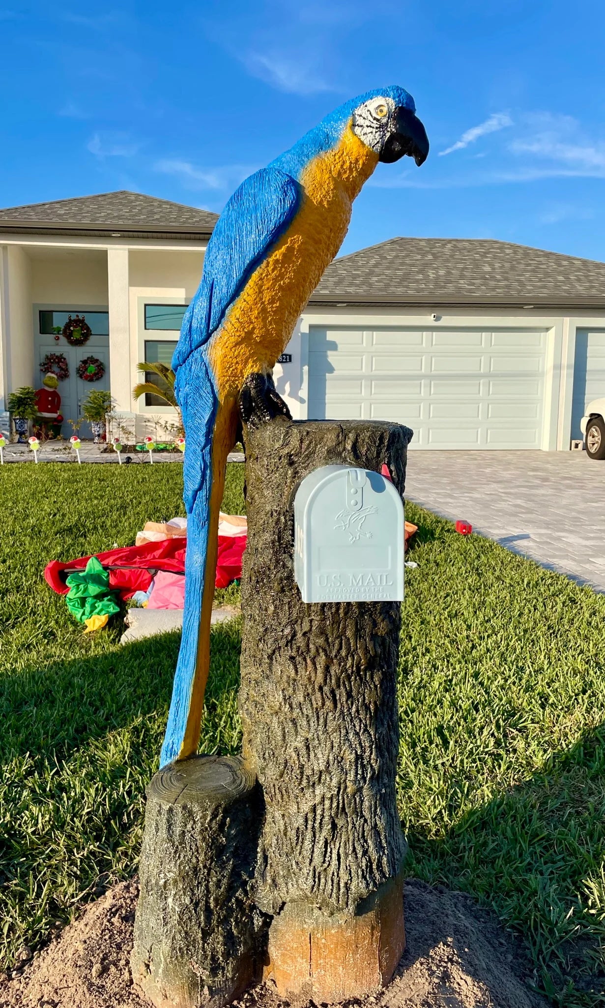 Handcrafted blue macaw statue, yellow chest by Seaside Mailbox, nautical cement art for coastal homes.